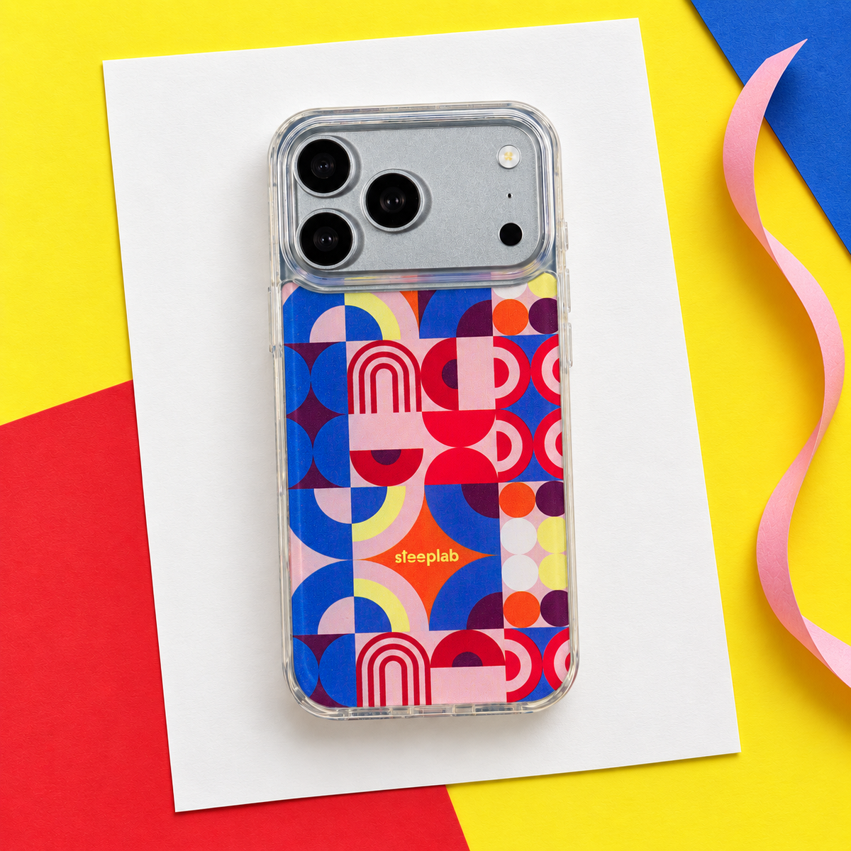 Freehand Case in Color Play for iPhone 18 Pro Max, multicolor geometric pattern, in a playful colored-paper scene.
