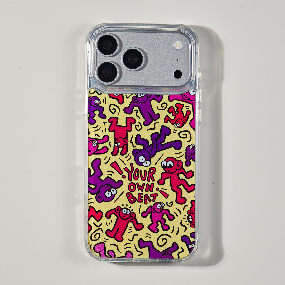 Freehand Case in Doodle Dance for iPhone 18 Pro Max, yellow design with red and purple dancing characters, shown from the back on a neutral studio background.