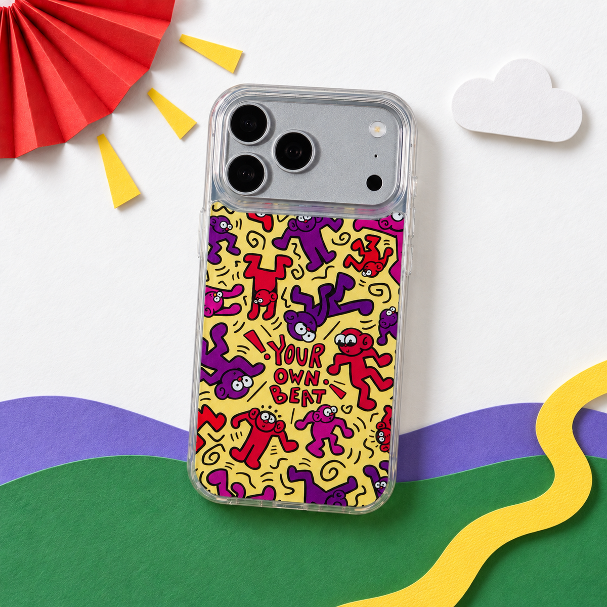 Freehand Case in Doodle Dance for iPhone 18 Pro Max, yellow design with red and purple dancing characters, in a playful colored-paper scene.