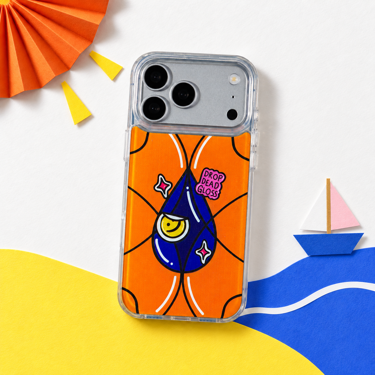 Freehand Case in Gloss Drop for iPhone 18 Pro Max, orange design with a blue illustrated drop, in a playful colored-paper scene.