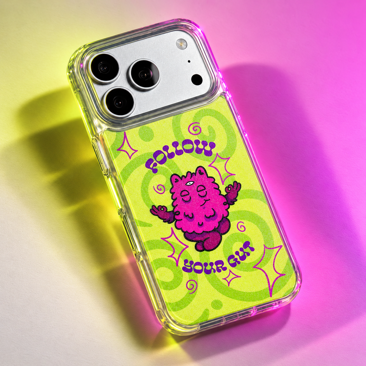 Freehand Case in Gut Feeling for iPhone 18 Pro Max, lime design with a pink illustrated character, under colored gel studio lighting.