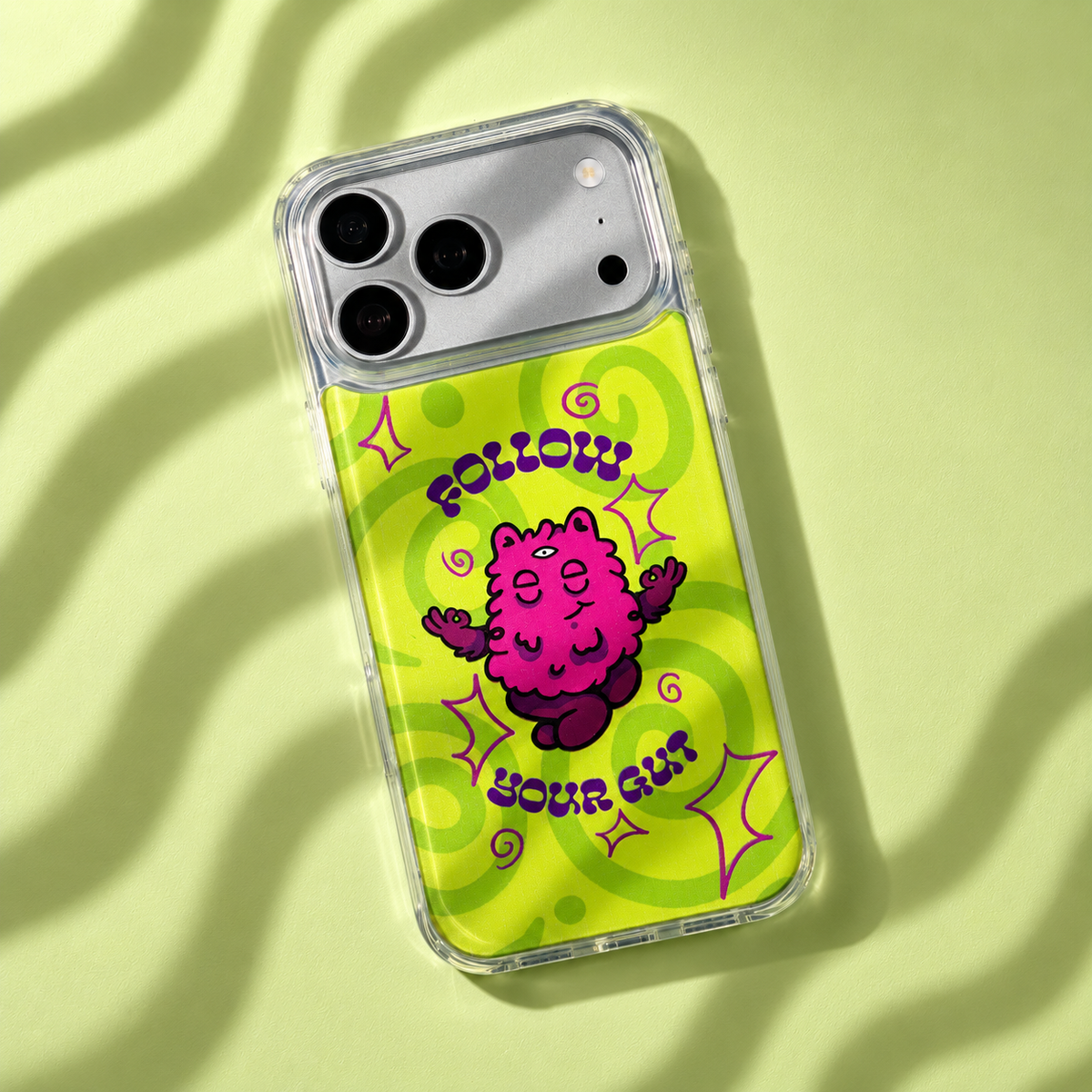 Freehand Case in Gut Feeling for iPhone 18 Pro Max, lime design with a pink illustrated character, with patterned studio light and shadows.
