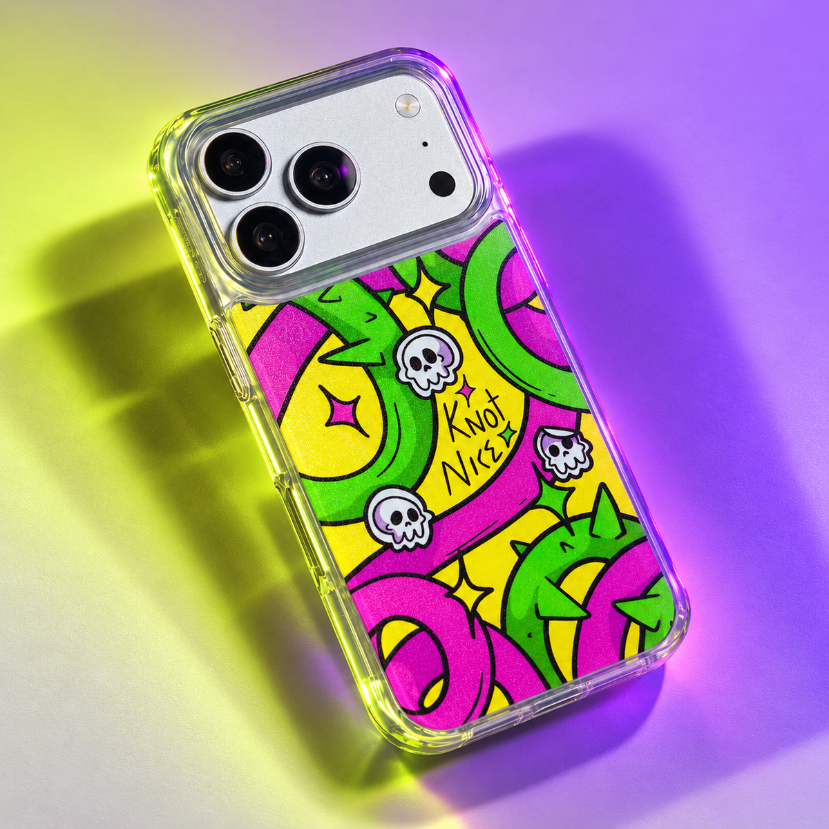 Freehand Case in Neon Knots for iPhone 18 Pro Max, bright yellow, pink and green ribbon design, under colored gel studio lighting.
