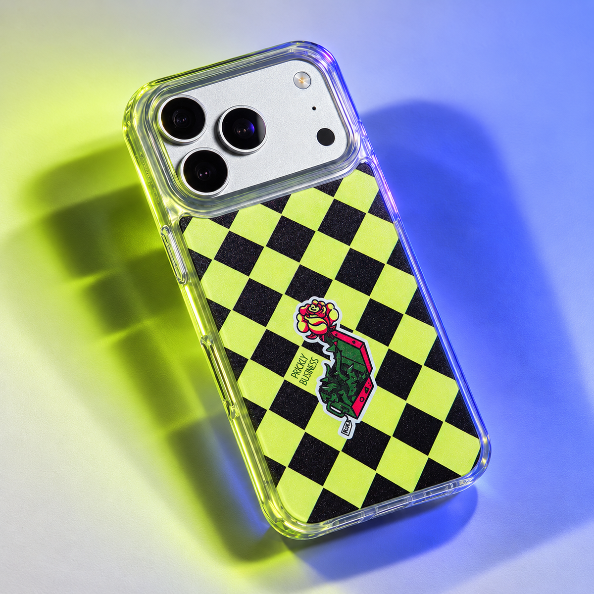 Freehand Case in Prickly Business for iPhone 18 Pro Max, chartreuse and black checkerboard design, under colored gel studio lighting.