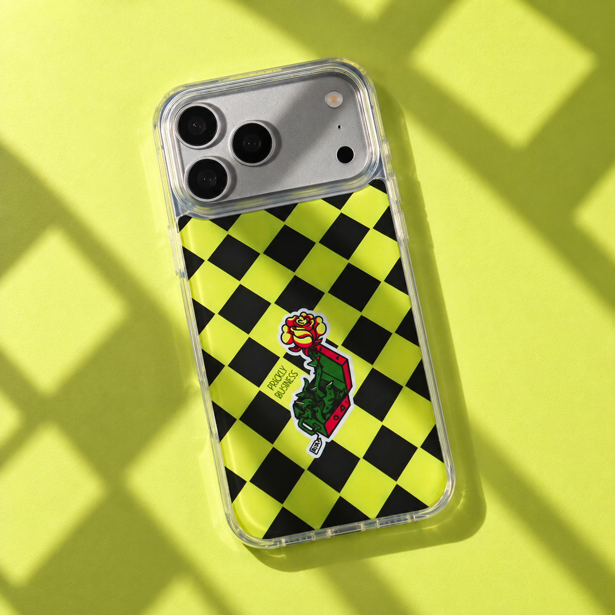 Freehand Case in Prickly Business for iPhone 18 Pro Max, chartreuse and black checkerboard design, with patterned studio light and shadows.