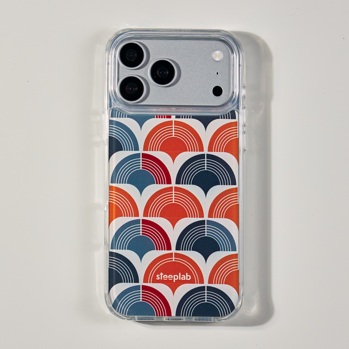 Freehand Case in Retro Ripple for iPhone 18 Pro Max, red and blue repeating arch pattern, shown from the back on a neutral studio background.