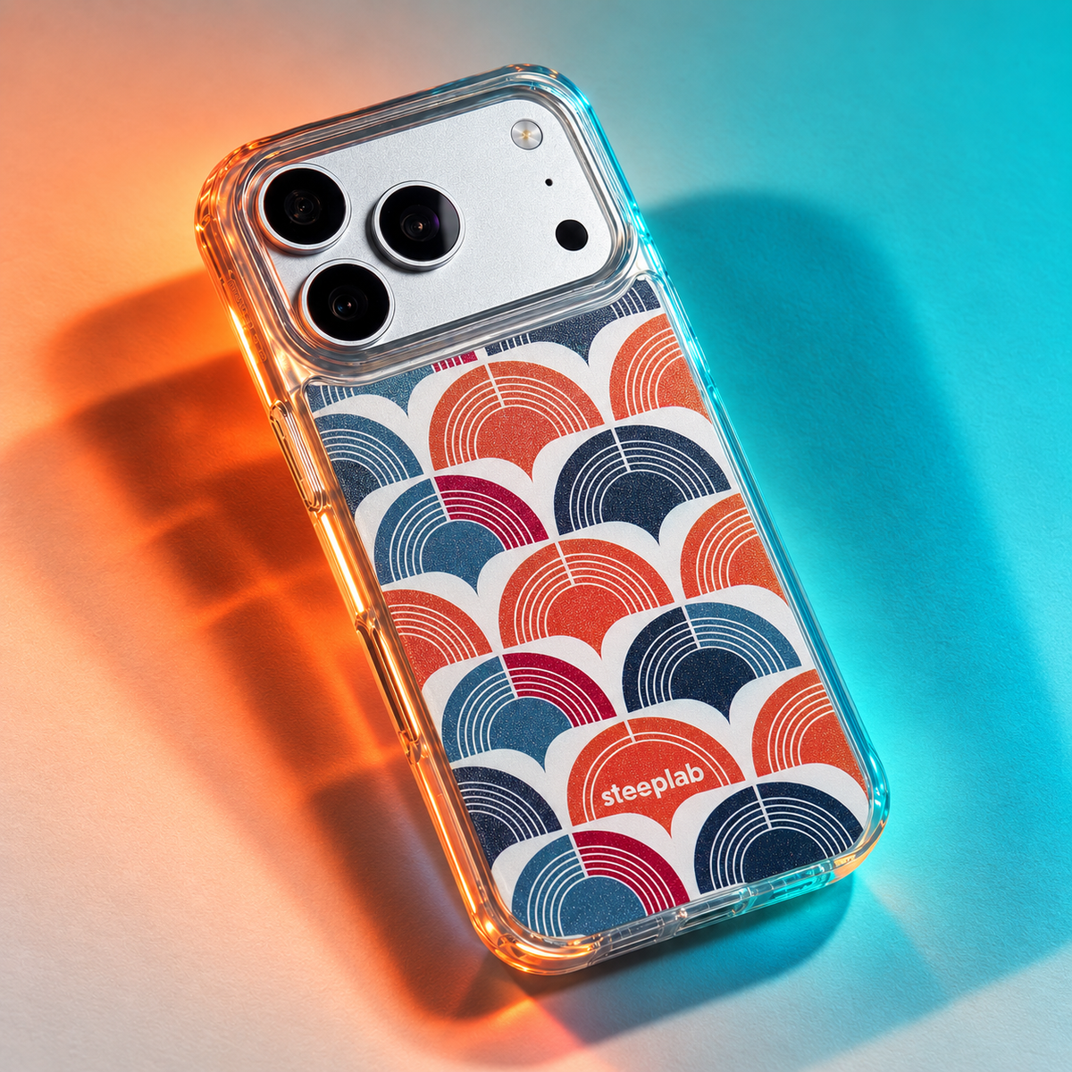 Freehand Case in Retro Ripple for iPhone 18 Pro Max, red and blue repeating arch pattern, under colored gel studio lighting.