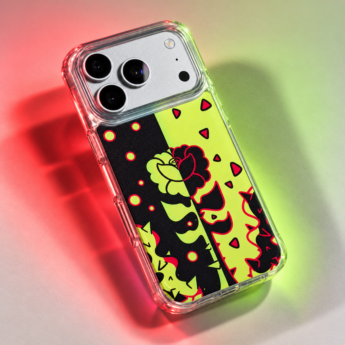 Freehand Case in Split Bloom for iPhone 18 Pro Max, black and chartreuse split floral design, under colored gel studio lighting.