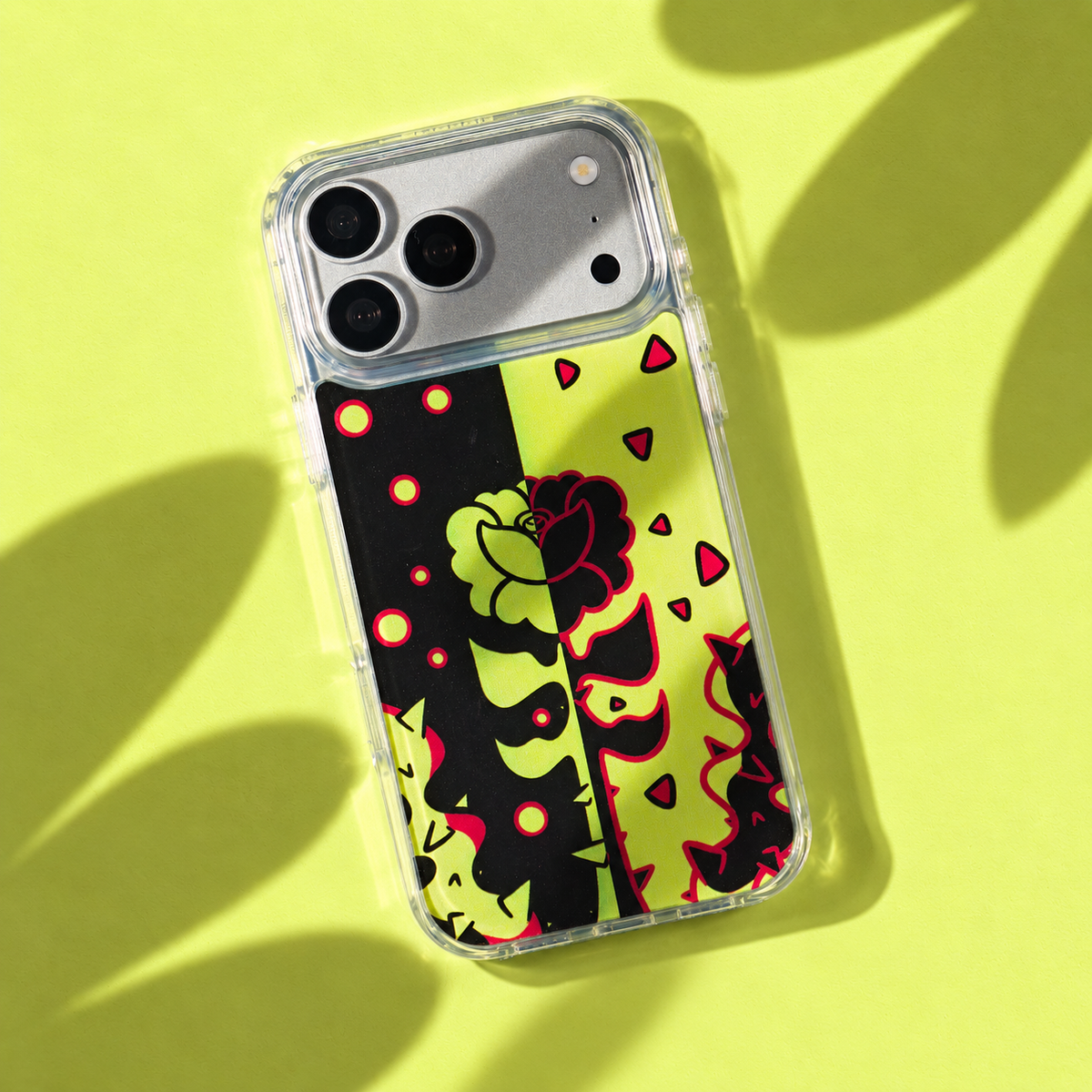 Freehand Case in Split Bloom for iPhone 18 Pro Max, black and chartreuse split floral design, with patterned studio light and shadows.
