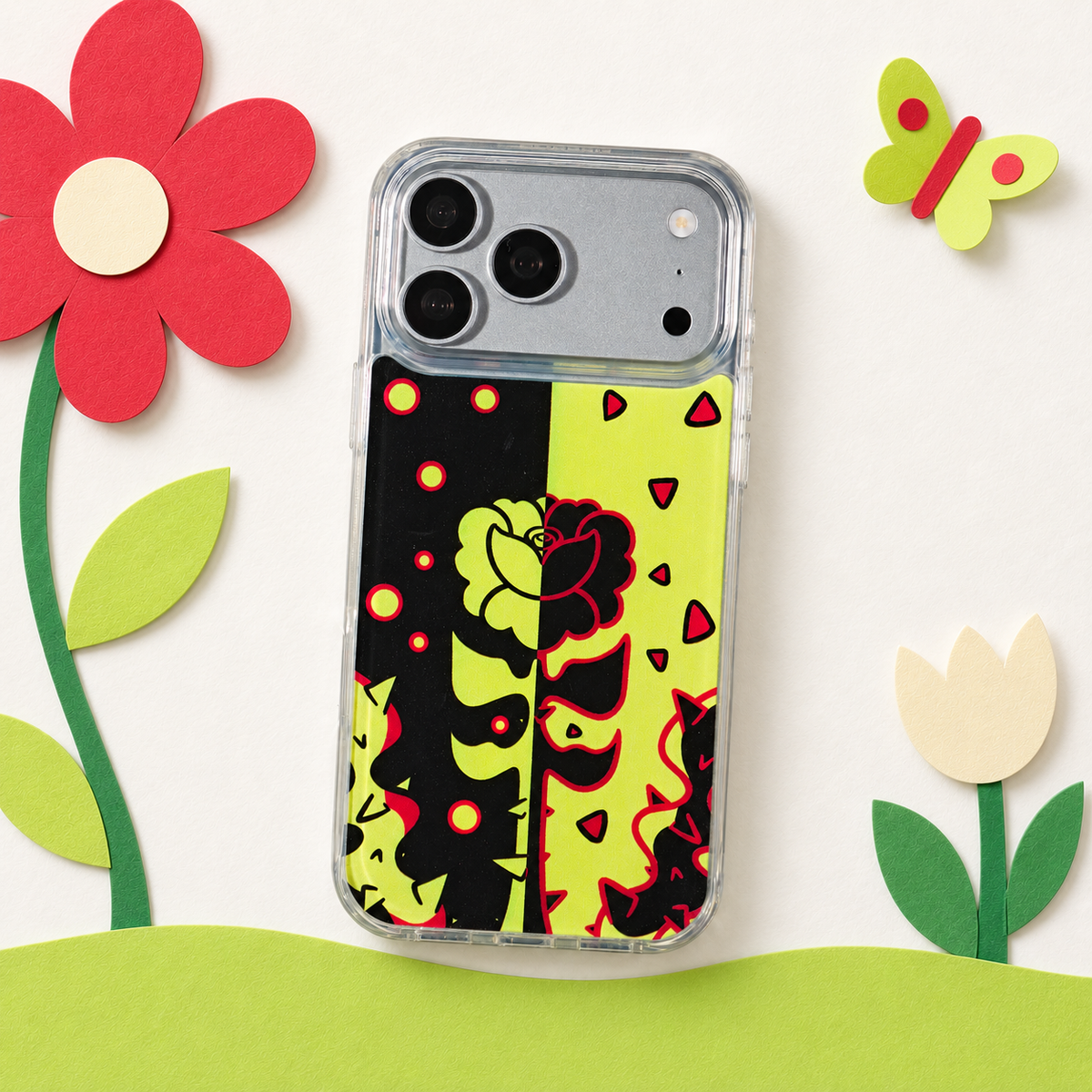 Freehand Case in Split Bloom for iPhone 18 Pro Max, black and chartreuse split floral design, in a playful colored-paper scene.