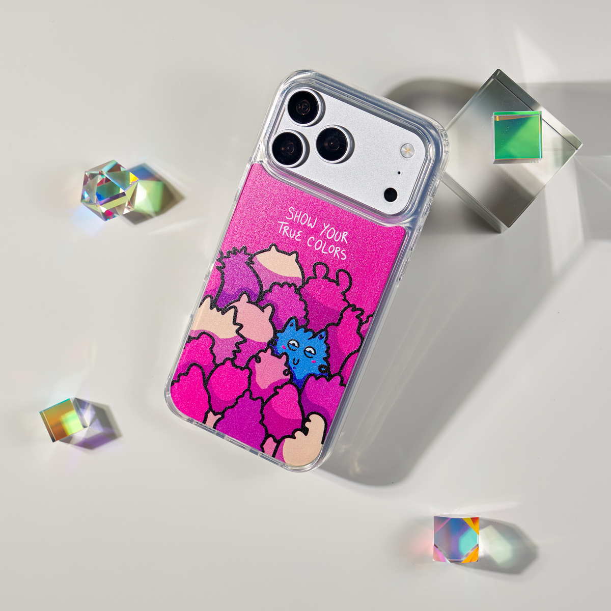 Freehand Case in True Colors for iPhone 18 Pro Max, pink design with colorful illustrated characters, shown at an angle with crystal props.